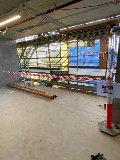 Barricaded work zone signed for concrete patching in progress on a multi-level build.